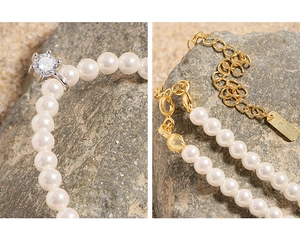 Detail view of S925 sterling silver stamp and lobster clasp on white pearl necklace