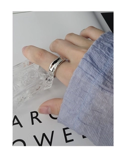 Detailed view of an irregular concave silver ring worn on hand with minimalist aesthetic