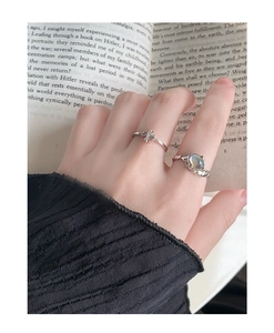 Détail de la bague en pierre de lune et de l'anneau croix sur des pages de livre