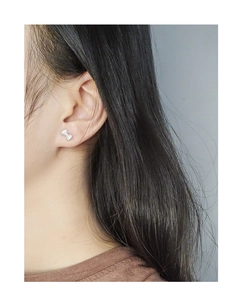 Close-up of S925 silver bow stud earrings with sparkling cubic zirconia on model