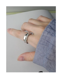 Close-up of a wide irregular concave silver open ring on finger with high polish finish