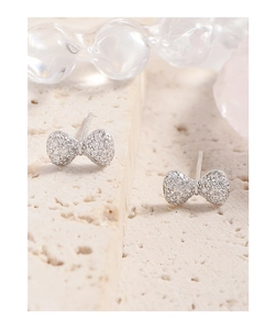 Macro detail of S925 silver bow earrings with micro-paved cubic zirconia stones