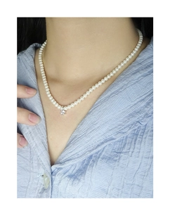 Detailed view of S925 silver pearl necklace with zircon pendant worn on neck