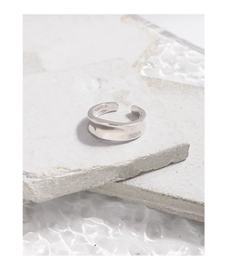 Detailed view of an irregular wavy concave surface on a silver S925 open ring