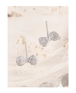 Macro shot of silver bow stud earrings with sparkling cubic zirconia pavé and hollow back detail