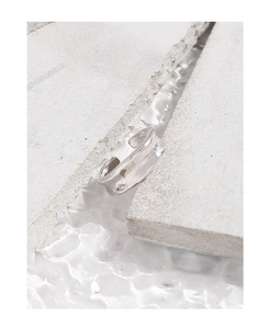 Macro shot of minimalist S925 silver irregular hammered texture ring on concrete base