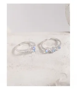 Macro view of S925 silver rings with hammered texture and iridescent moonstones