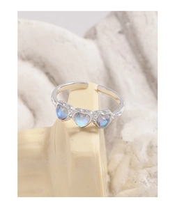 Detailed view of S925 silver ring featuring three moonstone hearts on a stone pedestal