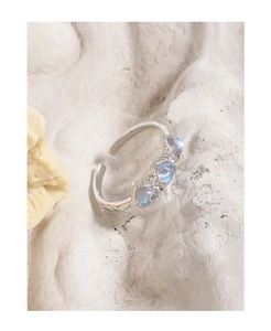 Detail of S925 silver heart moonstone ring with hammer textured finish and blue fire