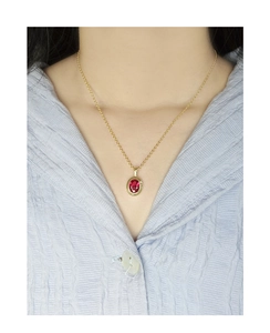 Close-up of a S925 silver gold necklace featuring an oval red zircon pendant worn on a model