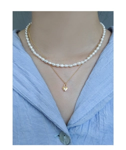Gros plan du collier double rang avec perles et pendentif serrure en cœur serti de zircon