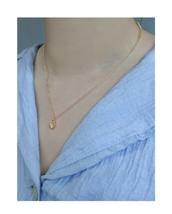 Gros plan d'un collier doré avec pendentif cadenas en cœur et pierre de zircon cubique