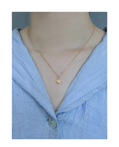 Gros plan d'un collier avec pendentif cadenas en cœur doré et zircon sur un mannequin