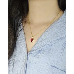 Elegant gold S925 silver necklace with oval red zircon pendant worn on female model