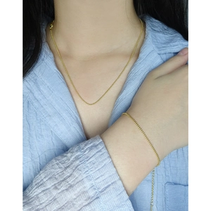 Ensemble bracelet et collier en argent S925 avec perles dorées porté par un mannequin