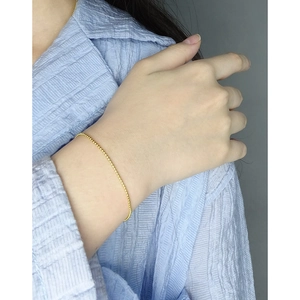 Bracelet minimaliste en argent S925 avec perles dorées pour femme porté au poignet
