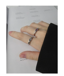 Macro detail of irregular S925 silver ring featuring a pink zircon and fluid metal design