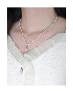 Detail of elegant S925 silver shell pearl necklace on model with white blouse