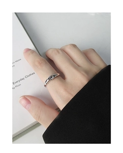 Detail of minimalist S925 sterling silver ring with irregular fluid design on finger