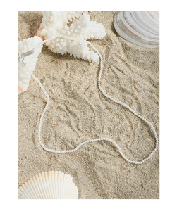 Detailed view of S925 sterling silver clasp and small white pearls on beach sand