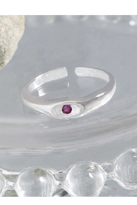 Macro shot of S925 silver ring featuring a round rose red zircon on a polished open band