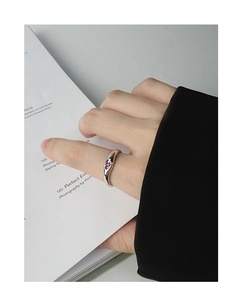 Macro shot of S925 sterling silver irregular ring with a small pink zircon on finger