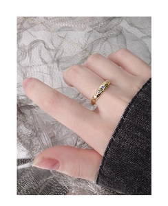 Détail de la bague texturée dorée avec zircons bleus et blancs portée par un mannequin