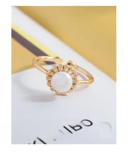 Macro view of gold flower bud ring with a central white pearl and delicate petal base