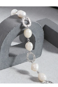 Macro view of S925 sterling silver stamp and irregular baroque pearls on bracelet