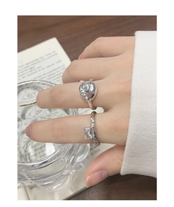 Detailed close-up of shell shaped silver ring and lava texture zircon band on hand