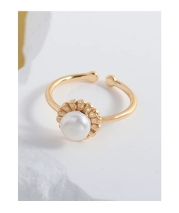 Detail of elegant gold-plated flower bud ring with a round white pearl on stone base