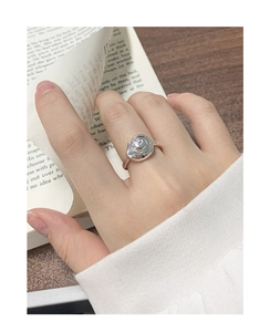 Close-up of silver conch shell ring on hand with elegant minimalist spiral design