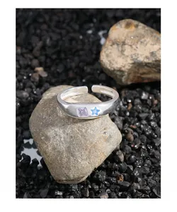 Detail of silver open ring with light purple square and blue star cubic zirconia stones
