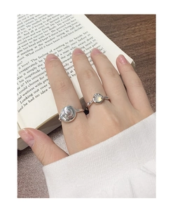 Close-up of S925 silver conch ring and moonstone set worn over a vintage book