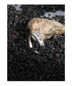 Detail of adjustable silver ring with blue star and purple square cubic zirconia stones