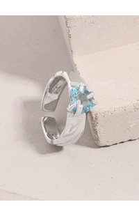 Macro detail of S925 silver ring featuring blue heart zircon and irregular lava texture