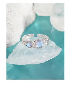 Macro detail of S925 sterling silver ring with irregular lava texture and blue moonstones