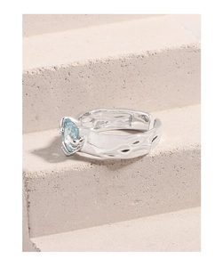 Macro detail of S925 silver ring featuring light blue zircon and irregular hammered texture