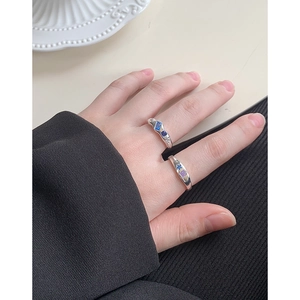 Minimalist S925 silver rings with blue and purple zircons on a model's hand