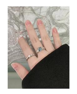Close-up of S925 silver heart ring set with blue zircon and pearl beads on hand