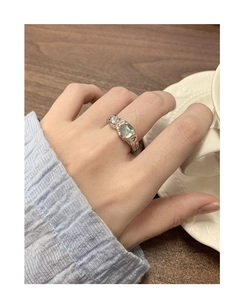 Detail of silver S925 moonstone ring with irregular liquid metal texture on hand