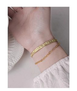 Detail of gold layered bracelet set with hammered texture and minimalist chain link