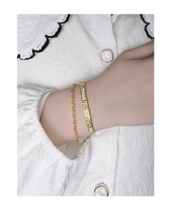 Detail view of gold S925 silver bracelet set with ripple texture and chain on wrist