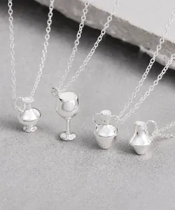Macro shot of miniature silver wine cup and bottle pendants on elegant silver chain