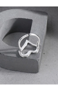 Macro detail of S925 sterling silver hollow heart ring on industrial stone prop