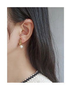 Close-up of S925 silver pearl stud earring with bamboo golden metal texture on ear