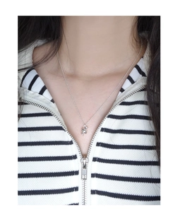 Close-up of polished S925 silver abstract disc pendant necklace worn by a fashion model