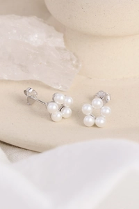 Detailed close-up of S925 silver pearl flower earrings on a ceramic tray with crystals