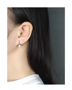 Macro side view of minimalist S925 silver pearl stud earring worn on model ear