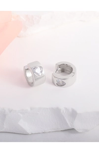Close-up of S925 sterling silver hoop earring with a sparkling heart zircon on a stone